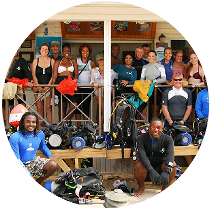 A group of people posing for a picture with their scuba gear at the Grenada Underwater Sculpture Park.