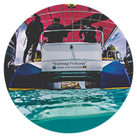 A group of people on a boat in the water, heading towards Grenada's Underwater Sculpture Park.