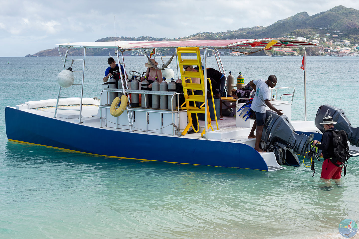 A group of people standing on a boat in the water, preparing for scuba diving in Grenada. A group of people standing on a boat in the water, preparing for scuba diving in Grenada.